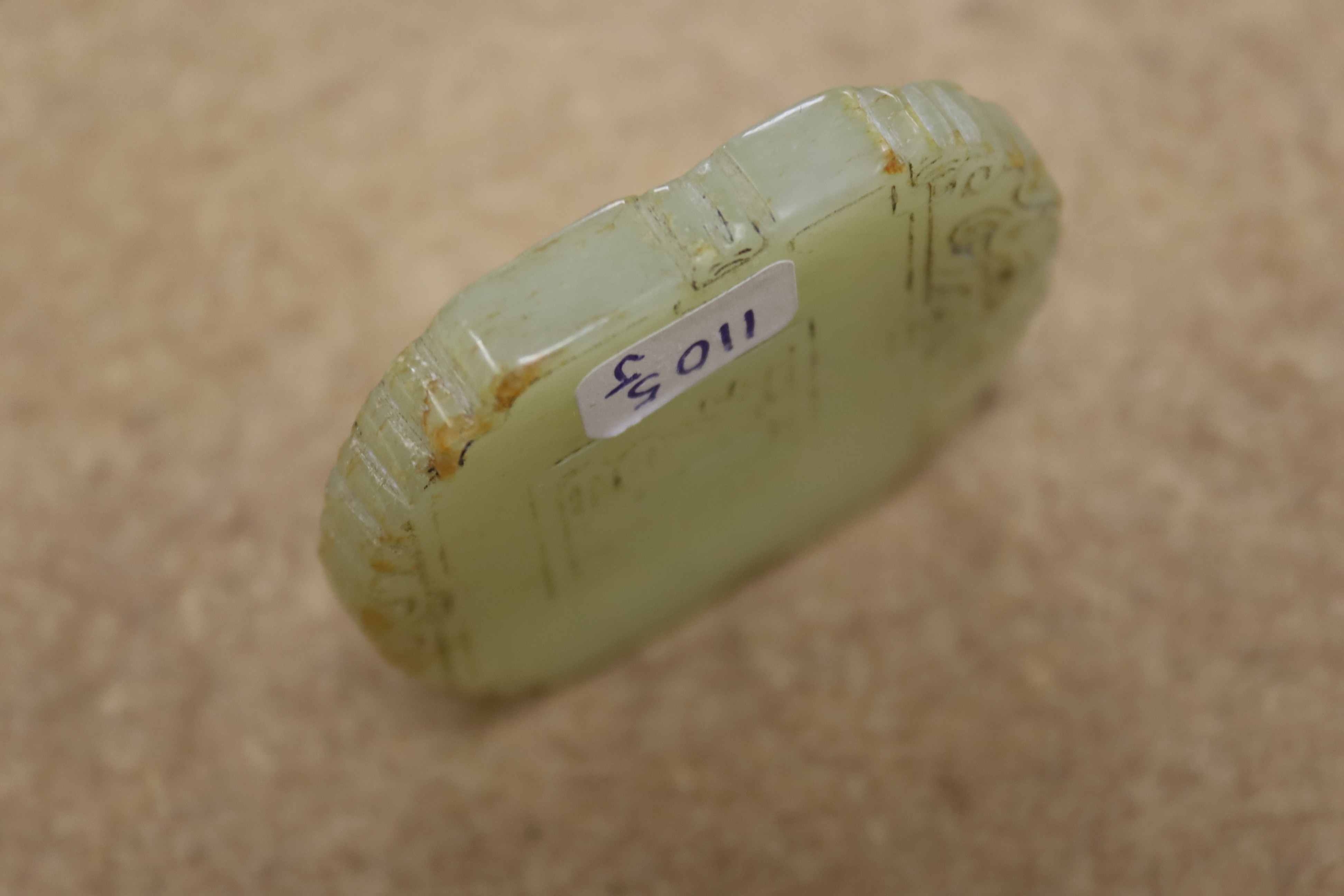 A Chinese pale celadon jade plaque, boy and bats, 5cm wide